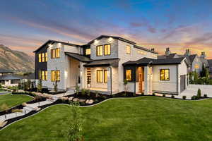 Contemporary house with a standing seam roof, a yard, stone siding, a metal roof, and covered porch