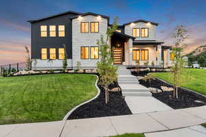 Modern home with stone siding, a standing seam roof, covered porch, and a metal roof