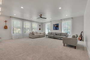 Living area with ceiling fan, light carpet, and recessed lighting