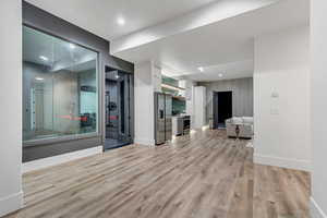 Exercise area featuring light wood-style floors and recessed lighting