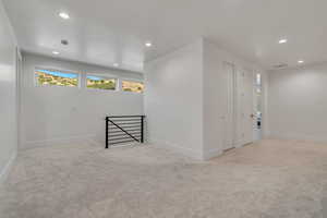 Empty room featuring recessed lighting and light carpet