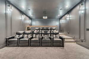 Home theater room with carpet floors, a textured ceiling, and recessed lighting