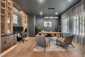 Office area featuring light wood-type flooring and recessed lighting