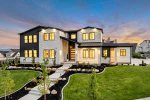 View of front facade with a front yard and stone siding