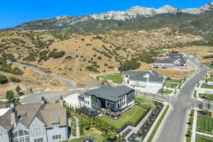 Aerial view of property and surrounding area featuring a mountainous background