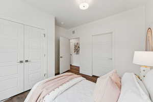 Spacious bedroom with vinyl floors and a large window.