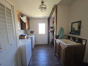 Laundry room with cabinet space, a heating unit, separate washer and dryer, and dark wood finished floors