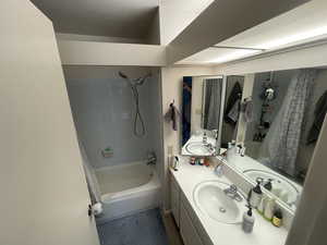 Bathroom with shower / bathtub combination with curtain and vanity