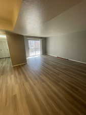 Unfurnished room with a textured ceiling and light wood-type flooring