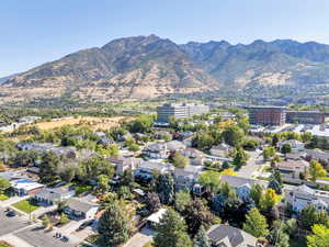 Aerial view of property and surrounding area with a mountain backdrop and nearby suburban area