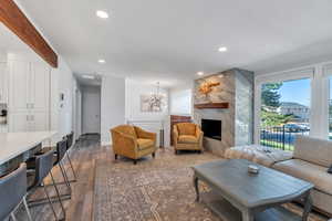 Living area featuring recessed lighting, dark wood finished floors, a chandelier, and a premium fireplace