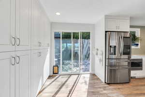 Kitchen featuring appliances with stainless steel finishes, white cabinetry, recessed lighting, and light wood-style flooring