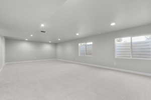 Empty room with recessed lighting and light carpet