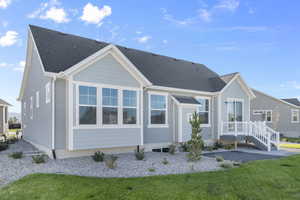 Back of property featuring roof with shingles and a lawn