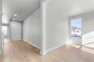 Hallway featuring light wood-type flooring and recessed lighting