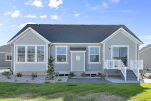 Rear view of property featuring a shingled roof and a yard