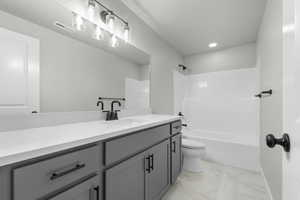 Full bathroom featuring vanity, bathing tub / shower combination, light marble finish floors, and recessed lighting