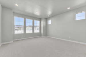 Empty room with carpet floors, recessed lighting, and healthy amount of natural light