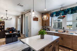 Kitchen featuring a center island, light wood-style flooring, open floor plan, healthy amount of natural light, and a textured ceiling