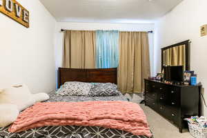 Carpeted bedroom featuring a textured ceiling