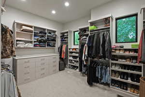 Walk in closet featuring light colored carpet