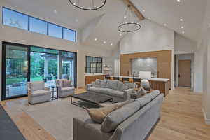 Living room featuring high vaulted ceiling, light wood-style floors, recessed lighting, and beamed ceiling