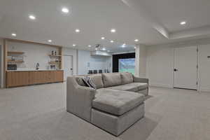 Living area featuring light colored carpet, recessed lighting, and wet bar