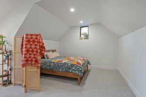 Bedroom with light carpet, lofted ceiling, and recessed lighting