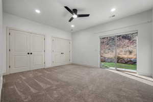 Unfurnished bedroom featuring multiple closets, carpet floors, recessed lighting, and a ceiling fan
