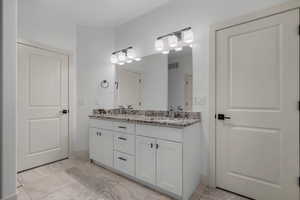 Bathroom featuring double vanity and baseboards