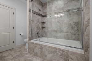 Bathroom with tiled shower / bath combo and toilet