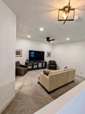 Living room featuring light colored carpet, attic access, recessed lighting, a textured ceiling, and a ceiling fan