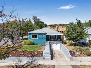 View of front of property featuring an attached garage, driveway, stairway, and covered porch