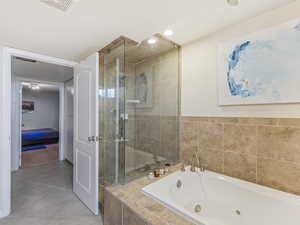 Full bath with a stall shower, a whirlpool tub, recessed lighting, and light tile patterned floors