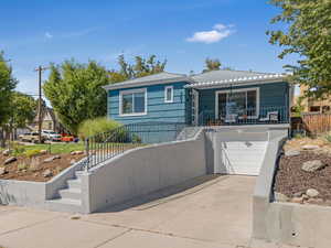 View of front facade with stairs, a garage, and driveway