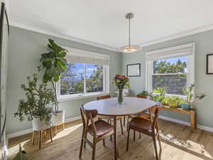 Dining space featuring light wood-style floors and ornamental molding