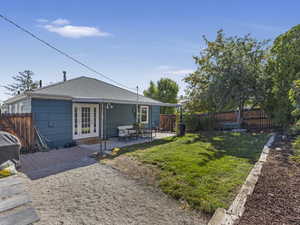 Back of house with roof with shingles, a fenced backyard, and a patio