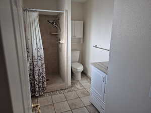 Bathroom featuring a stall shower, vanity, and light tile patterned flooring