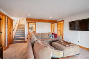 Living area featuring stairs, carpet, and recessed lighting