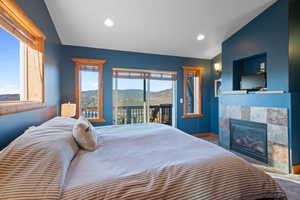 Bedroom with a fireplace, access to exterior, and recessed lighting
