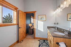 Bathroom with double vanity and light tile patterned flooring