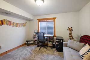 Carpeted office featuring baseboards