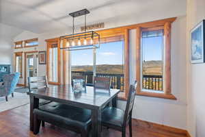 Dining area featuring plenty of natural light, hardwood / wood-style floors, vaulted ceiling, and a mountain view