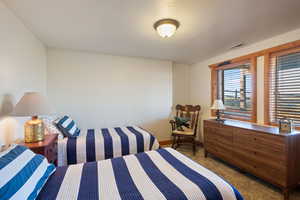 Bedroom featuring dark colored carpet and baseboards