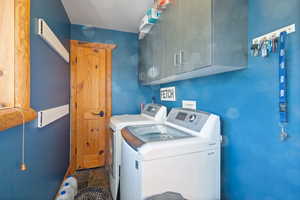 Washroom featuring washer and clothes dryer and cabinet space