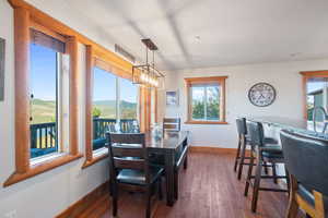 Dining room featuring a mountain view, dark wood finished floors, and a chandelier