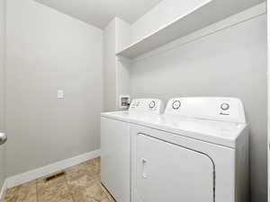 Laundry room featuring baseboards and washing machine and clothes dryer