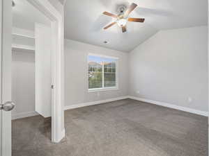 Unfurnished bedroom featuring light colored carpet, lofted ceiling, a ceiling fan, and a closet