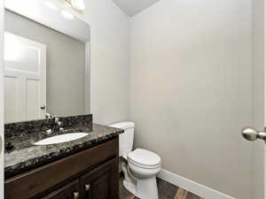 Half bath with vanity and dark wood-style flooring