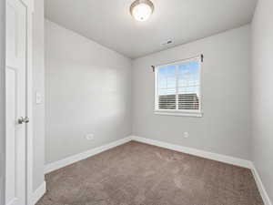 Carpeted empty room featuring baseboards and a textured ceiling